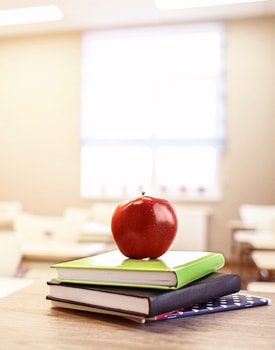 Apple sits on stacked books