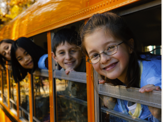 kids inside of bus looking at camera smiling