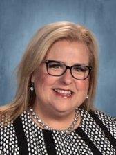 A stylish woman in glasses wearing a black and white dress.