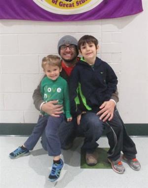 A man and two boys are posing for a picture