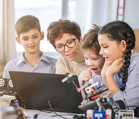 teacher showing something to her students in her laptop