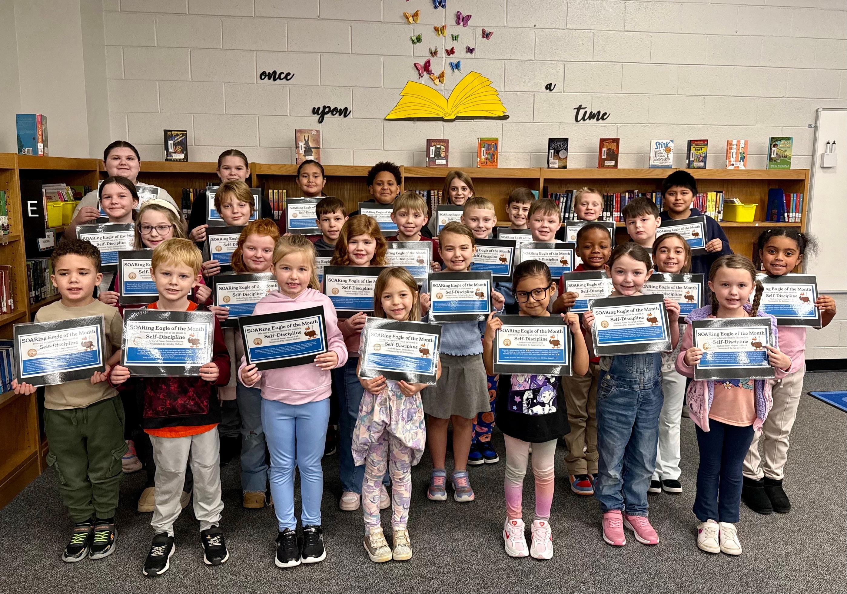 Students holding certificates after being recognized for being a SOARing Eagle