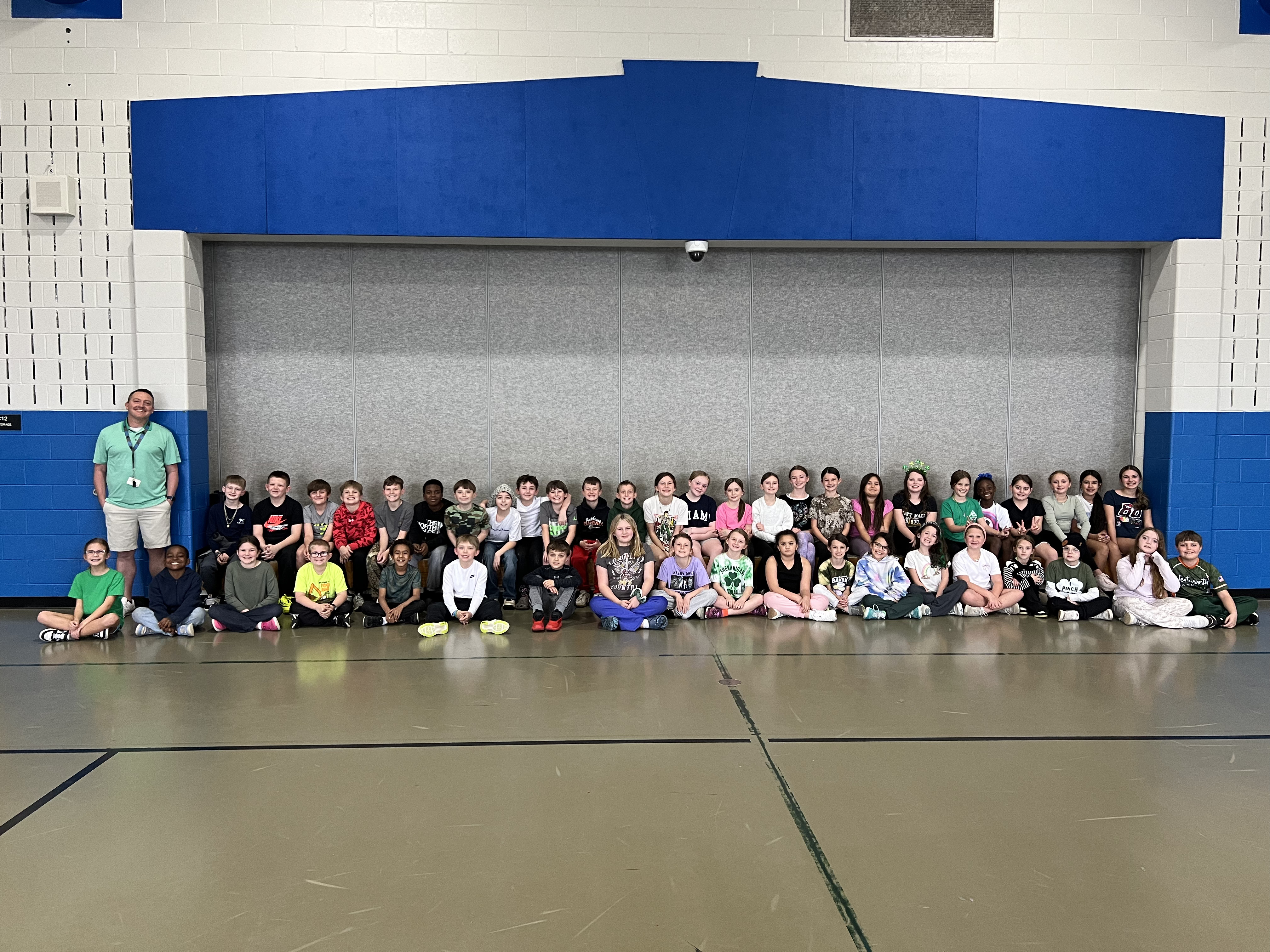 Running club studens seated in the gym 