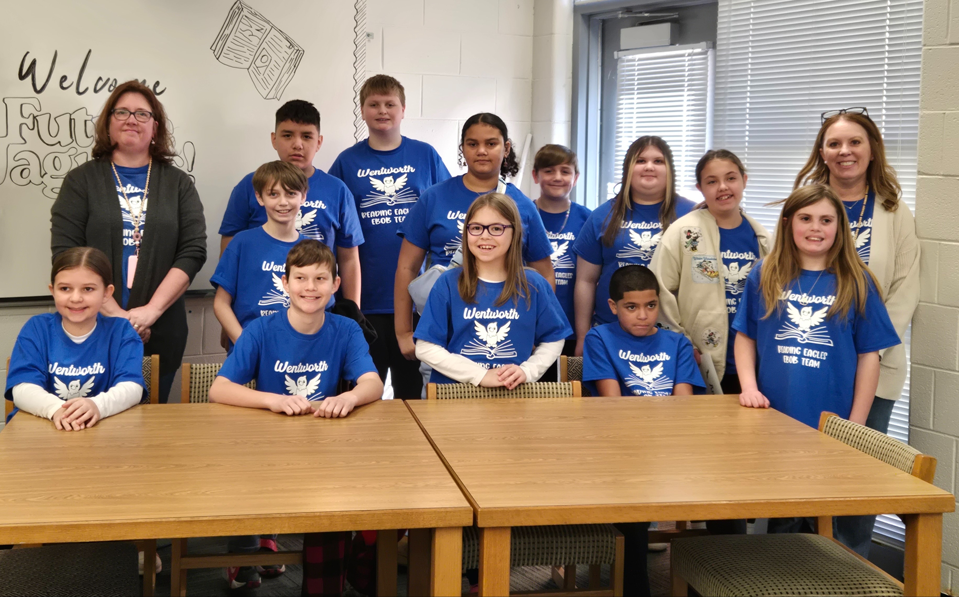 Battle of the Books students in  blue shirts seated at a table after competition
