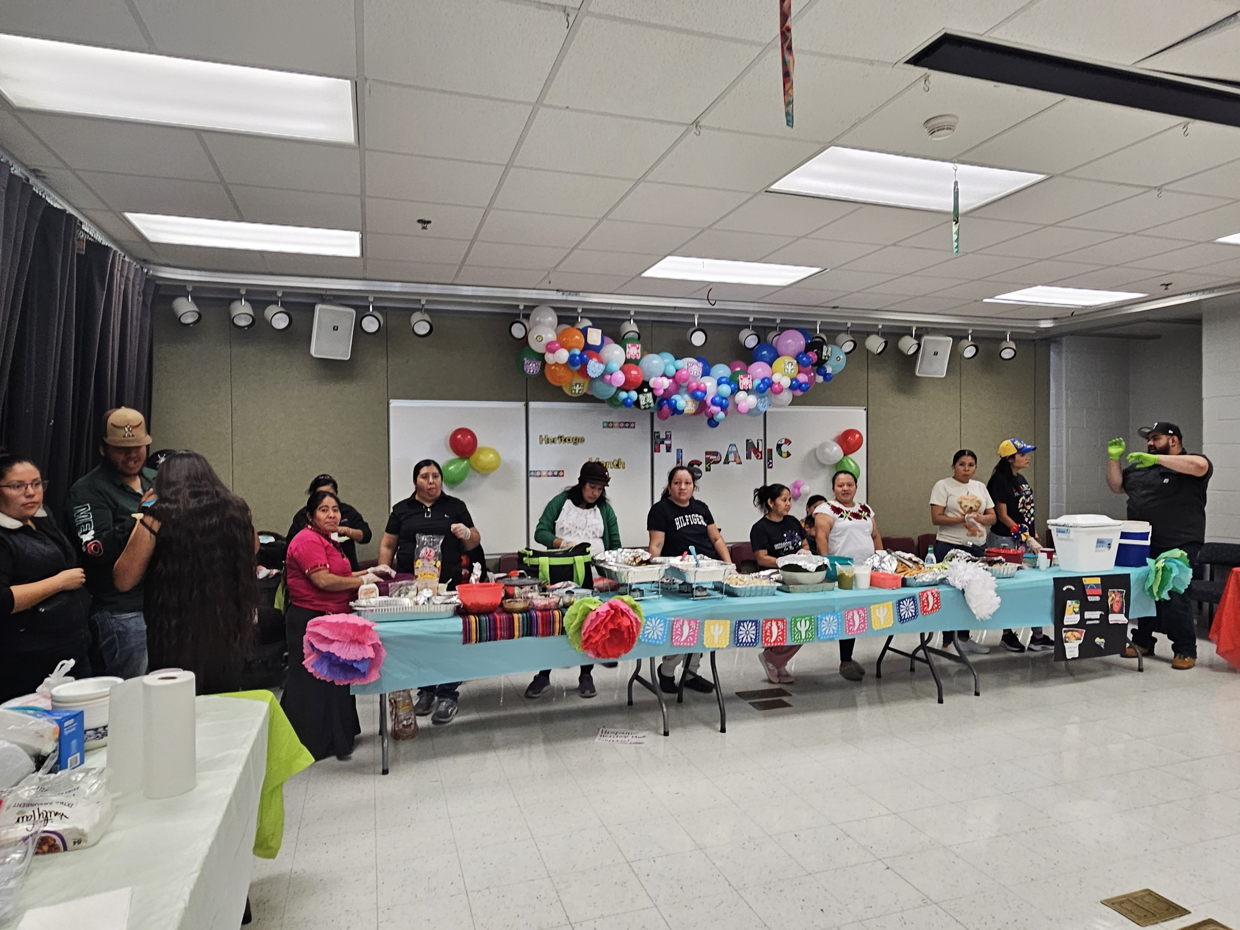 A group of parents serving traditional foods to staff members during the Hispanic Hertiage Month luncheon