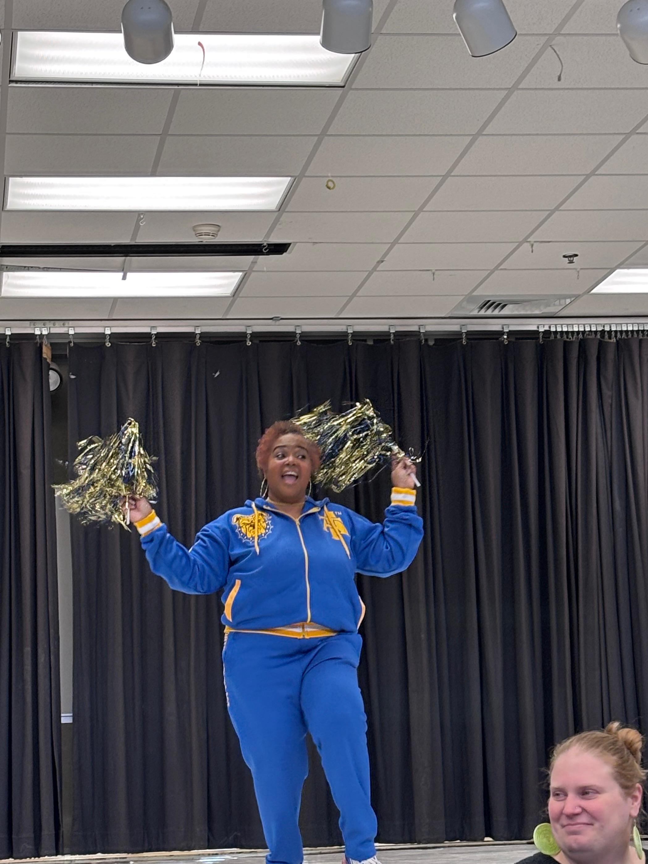 Mrs. Davis, the guidance counselor, cheering on stage as part of the Black History Month program