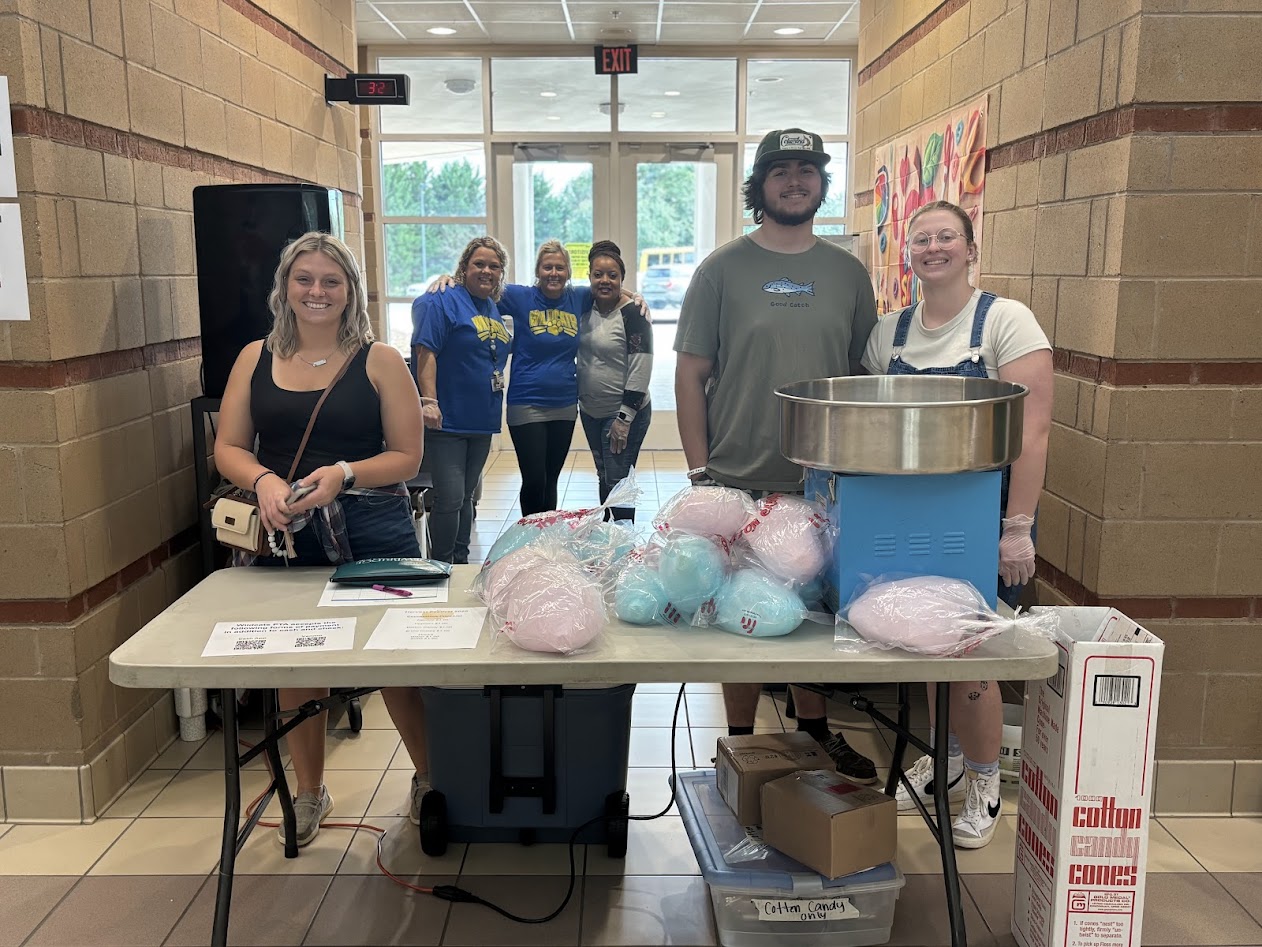 PTA members, teachers, and volunteers work the Cotton Candy table at the Harvest Festival