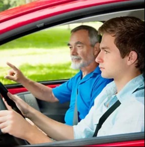 driving lessons - student behind wheel with instructor in passenger seat pointing)