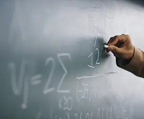 Teacher Writing a Formula on a chalkboard