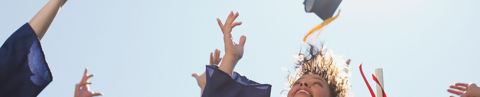 graduated students throwing their hats to the air