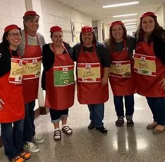 staff members each wearing a red apron 