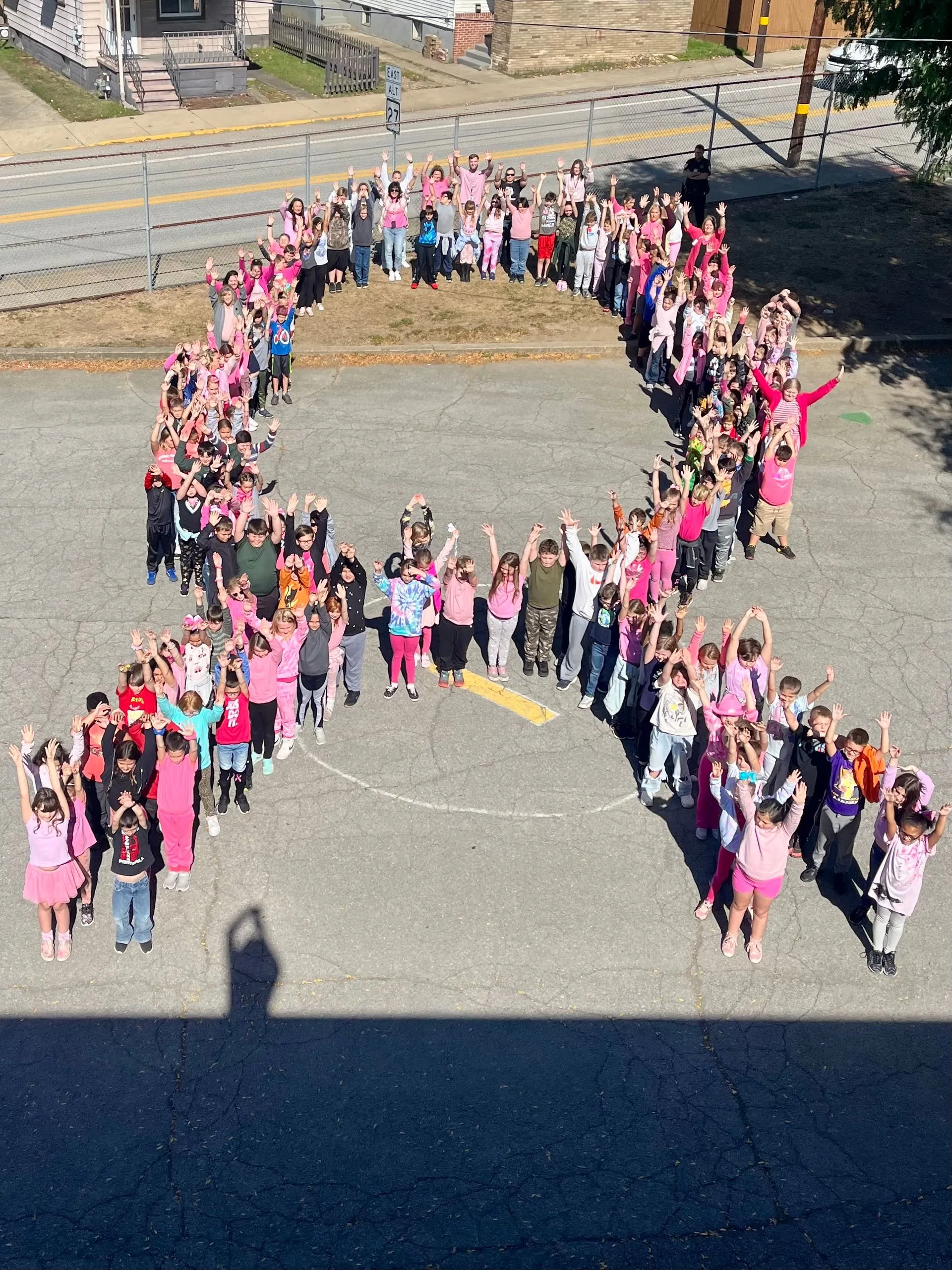 Group of people forming a ribbon for cancer awareness