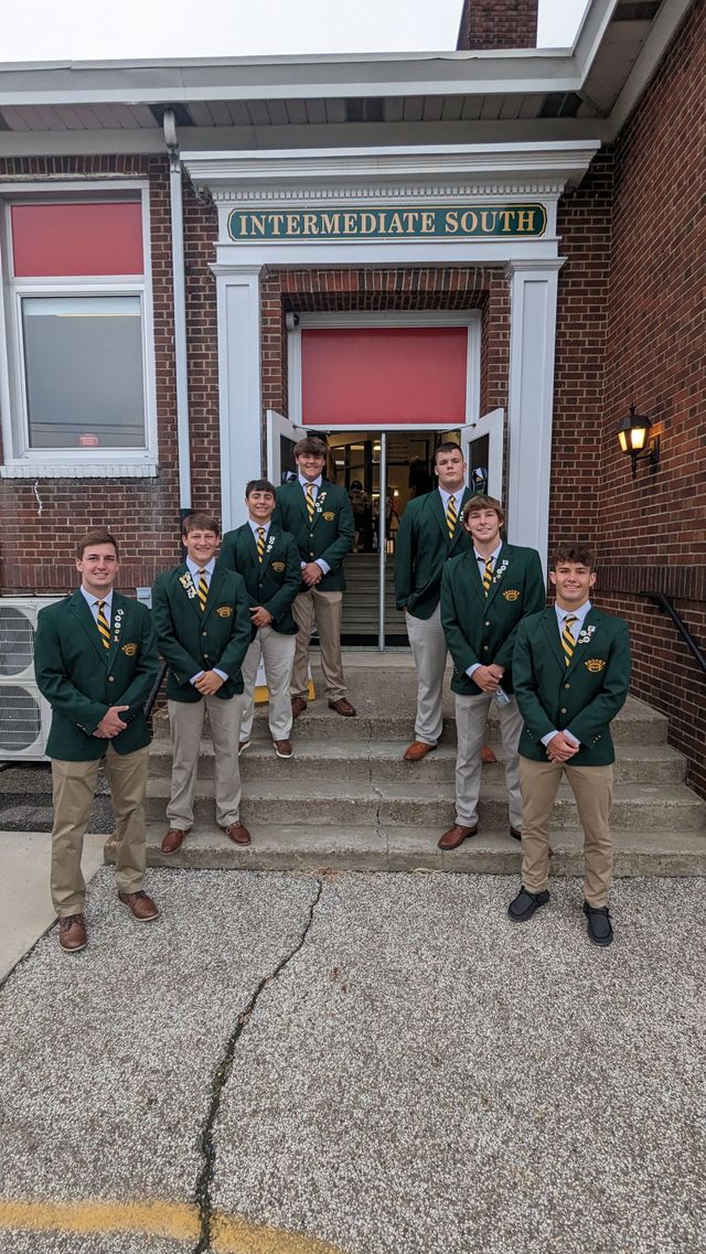 Group of students standing in front of a stairs.