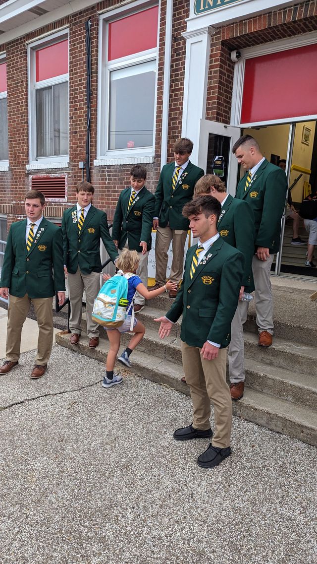 Group of students standing in front of a stairs.