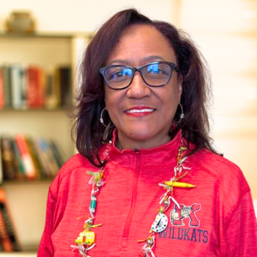 face black woman red shirt vibrant necklace in office