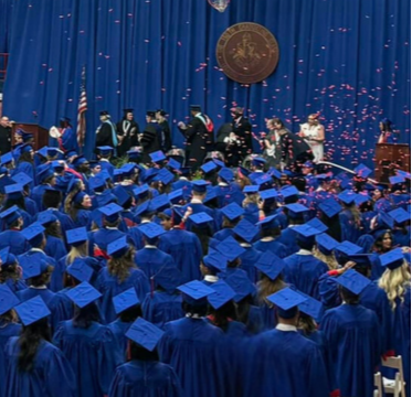 Graduation students in blue caps and gowns celebrating success confetti