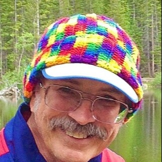 man with mustache wearing glasses and colorful hat