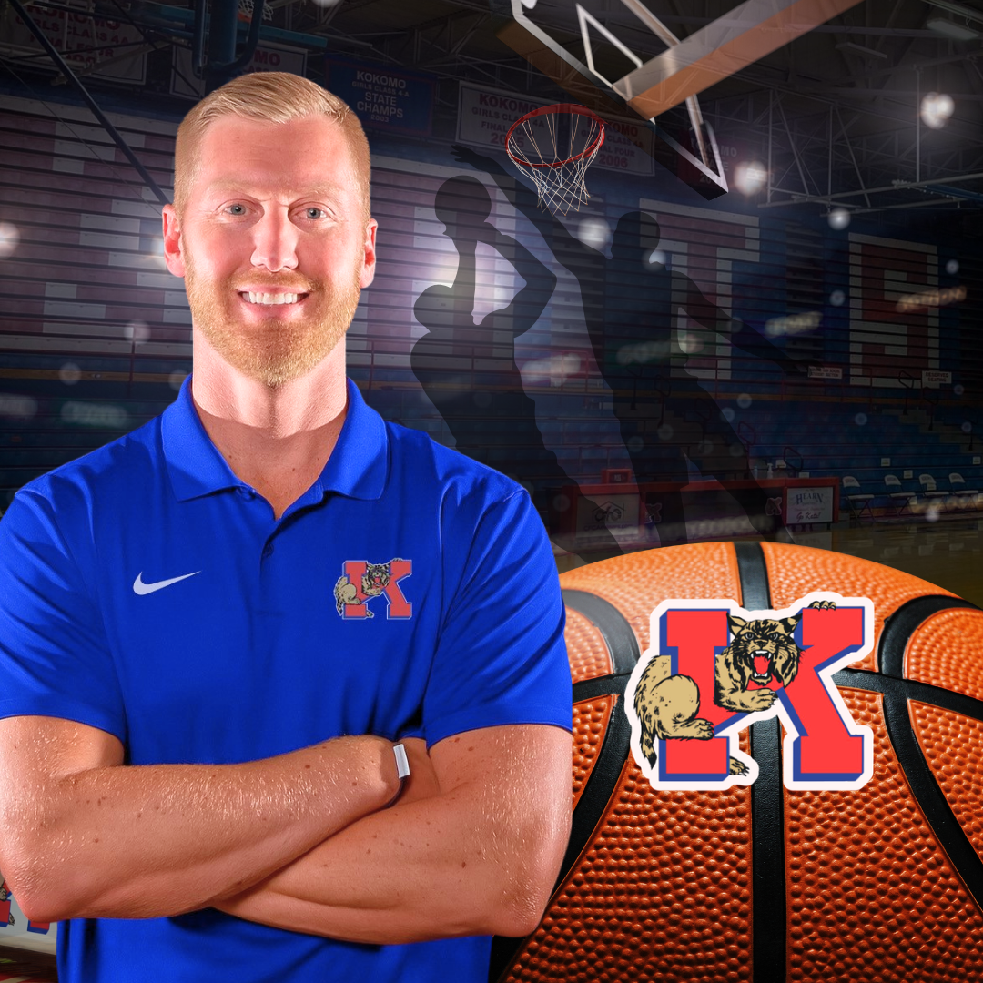 man smiling standing with arms crossed in front of basketball gymnasium