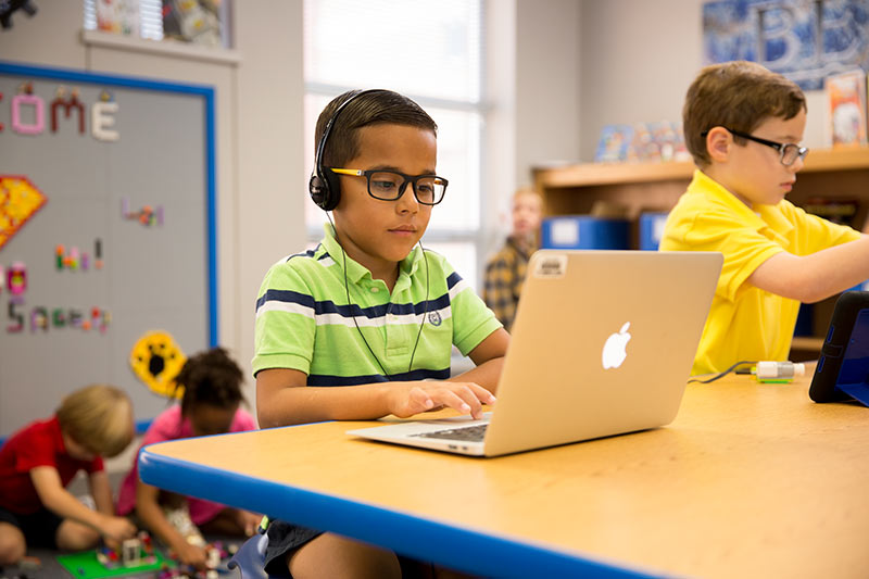 Bennett Elementary student uses a classroom laptop for his class project.