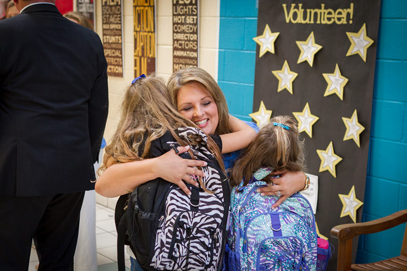 Teacher hugging students