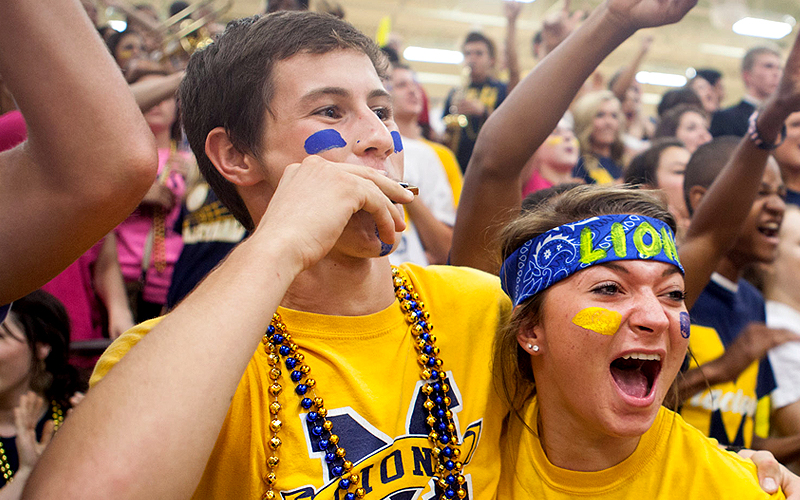 high school football fans cheering on their team