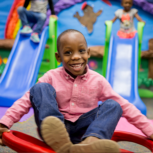 student playing on rocking toy