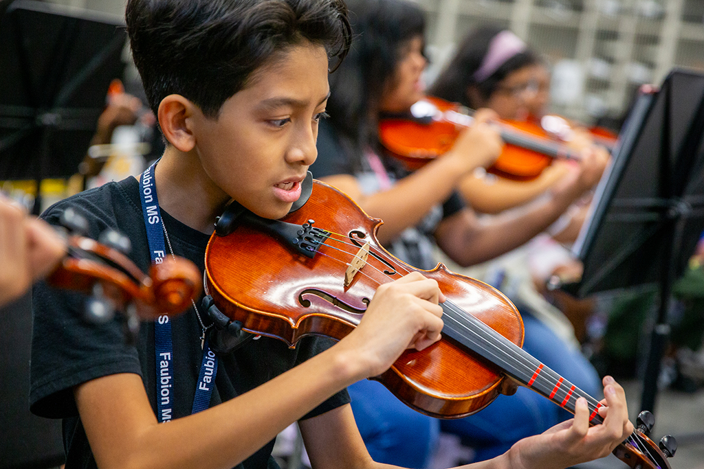 a student from faubion middle school plays the violin