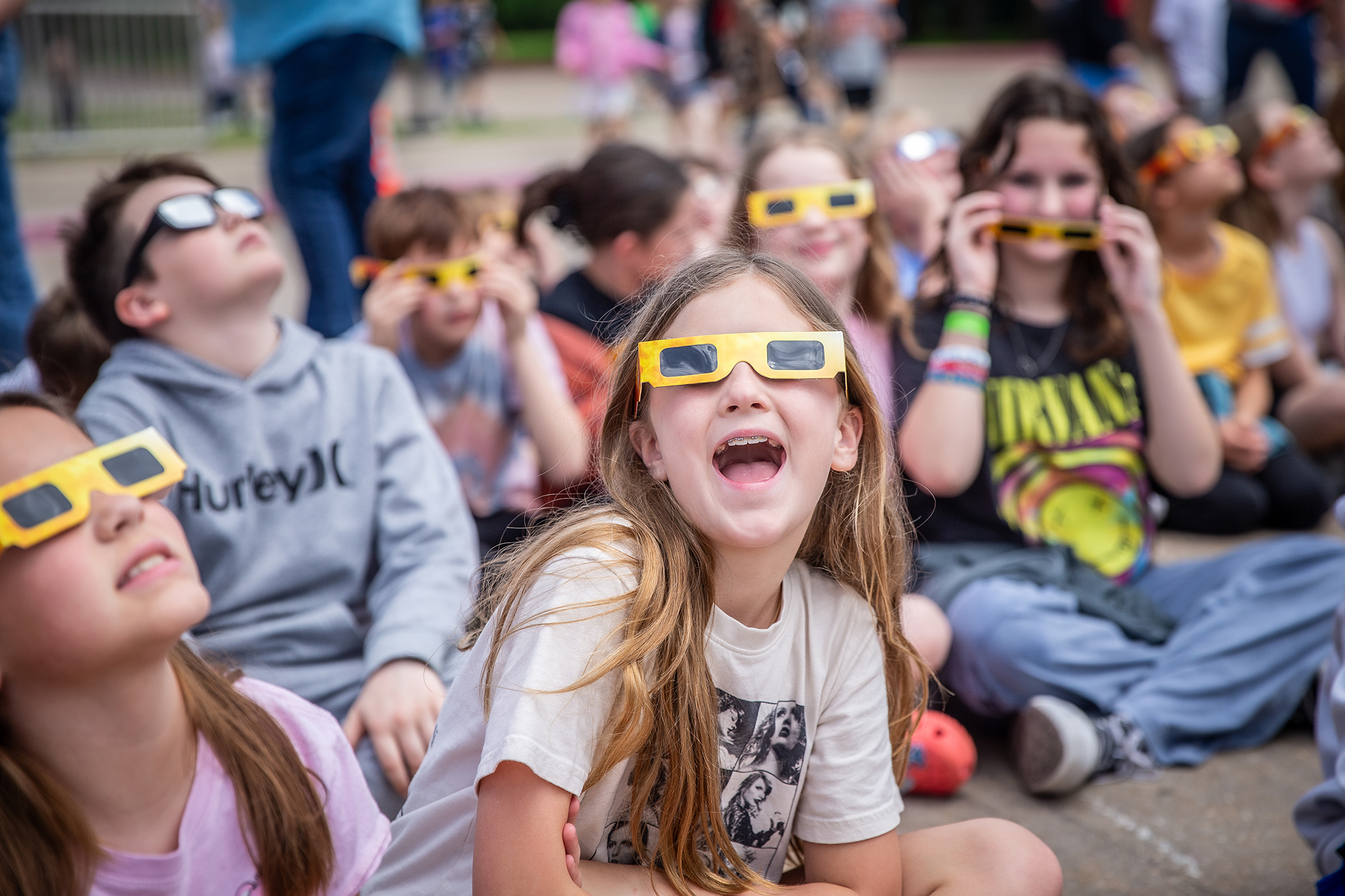 students watch the solar eclipse with safety glasses 
