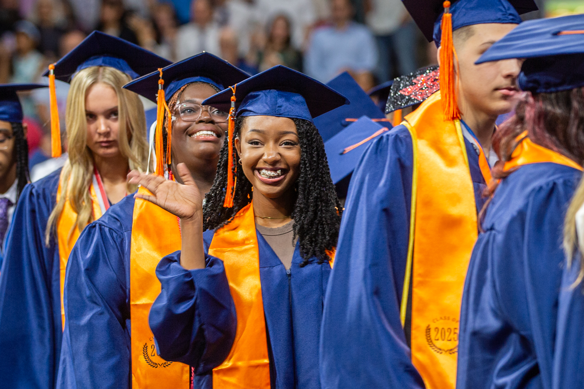 a student from mckinney north high school waves to the crowd at graduation