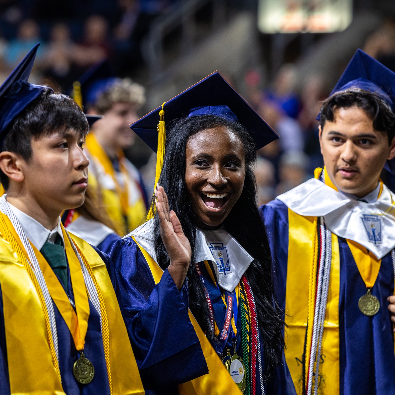 a student from mckinney high school waves to the crowd at graduation
