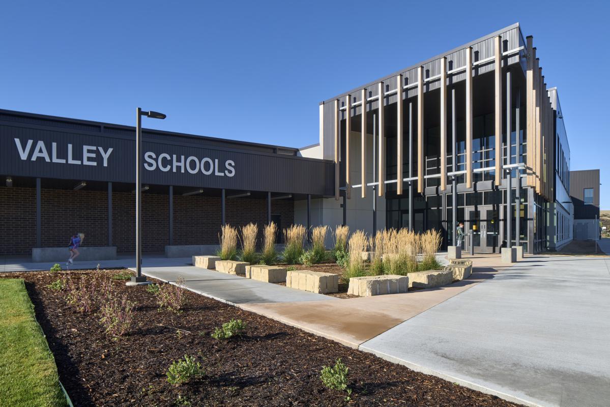 Exterior view of valley schools surrounded by lush greenery and rolling hills.