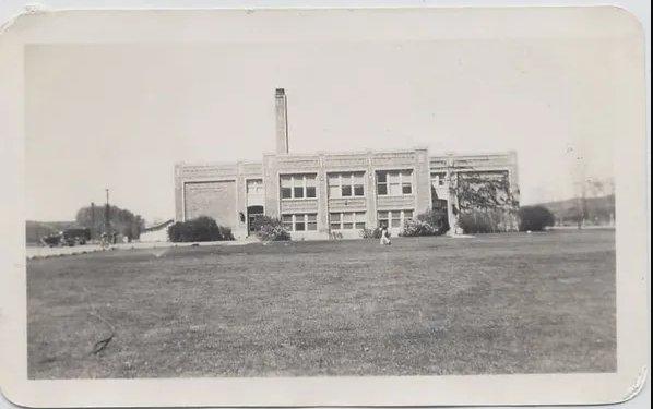 An aged school building with a chimney, showcasing the architectural charm of the past.