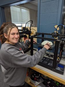 A picture of a woman doing maintenance on a robotic part