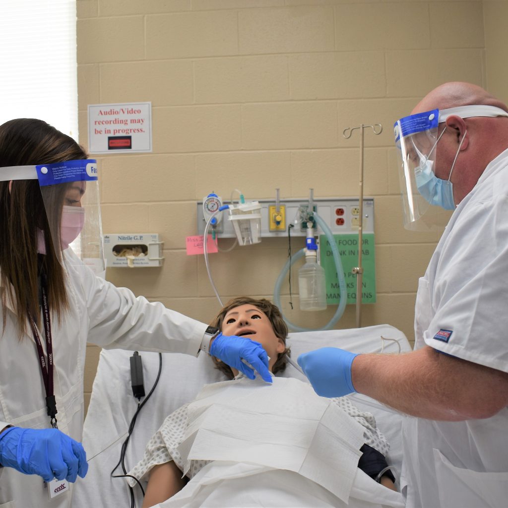 Two healthcare professionals are attentively attending to a patient in a clinical setting