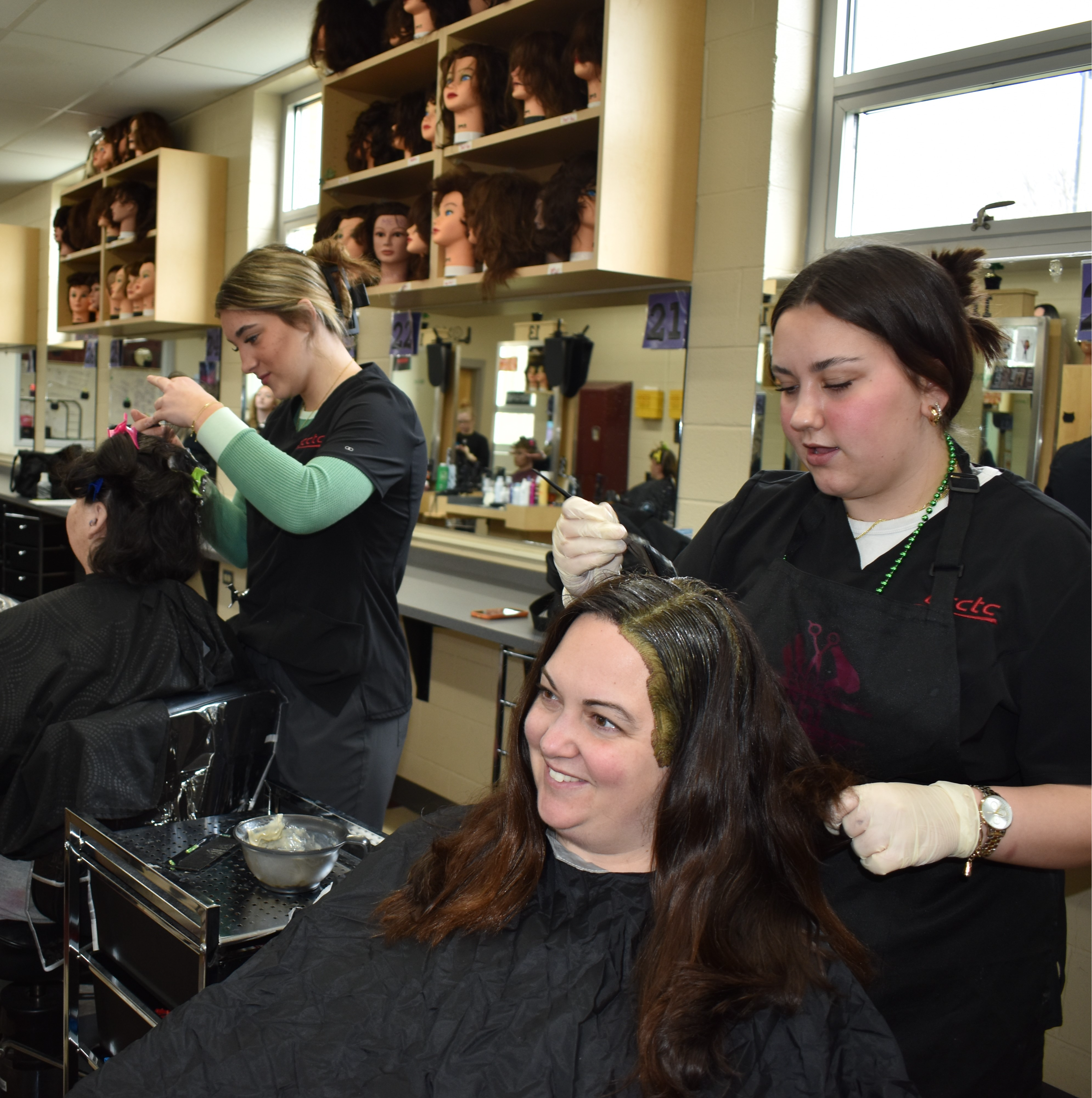 A bustling hair salon with multiple customers, featuring a stylist attentively working on a client’s hair