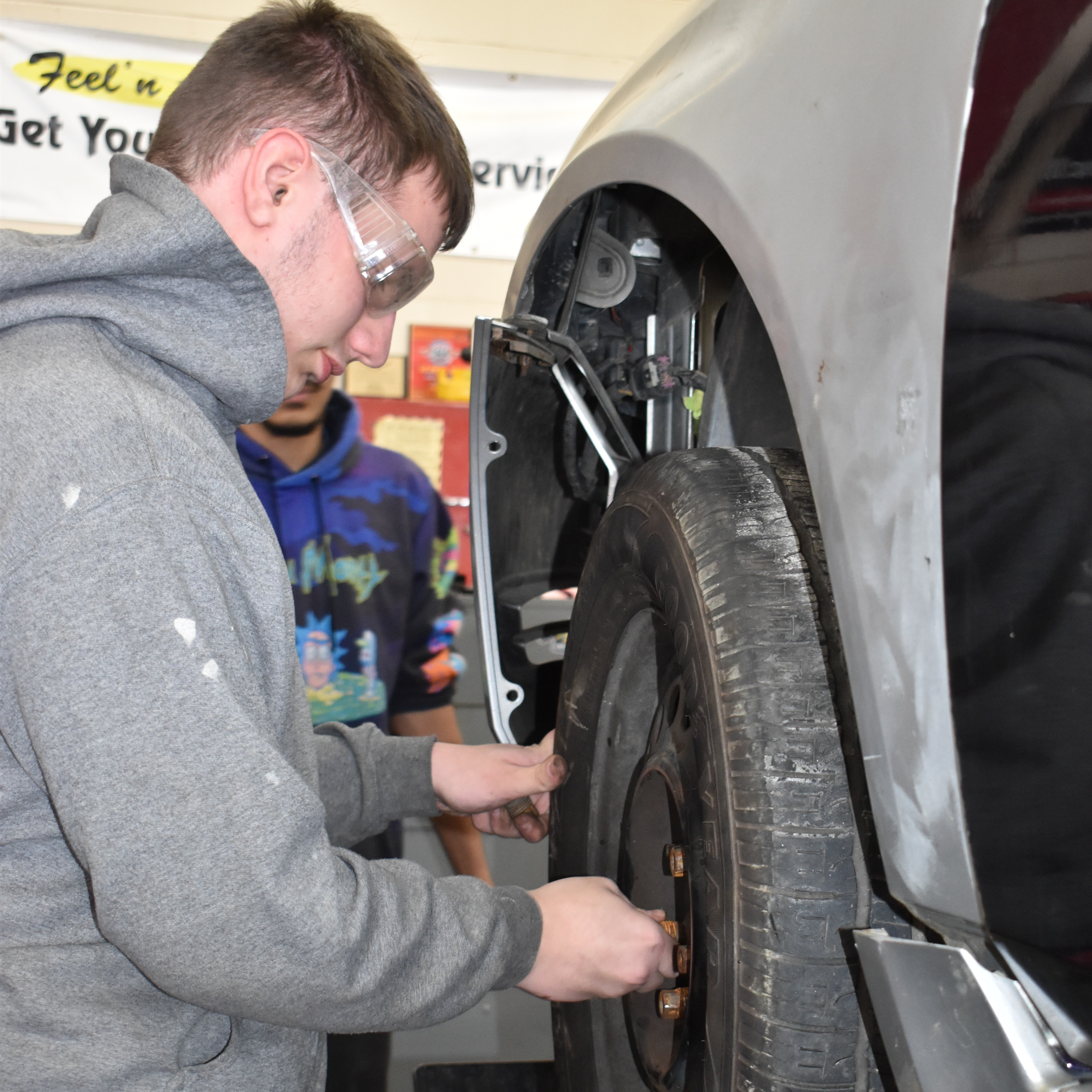Image of high school boy working on a car in a shop
