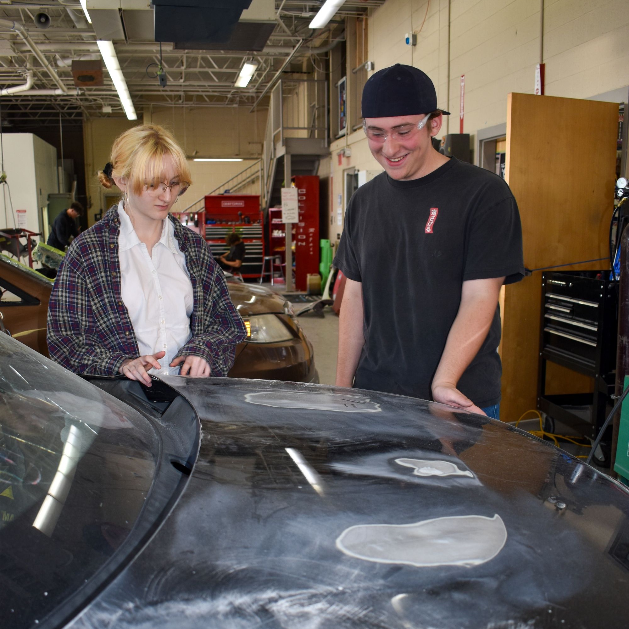 students sanding car body