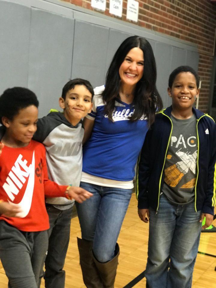 A woman posing for a picture with some kids