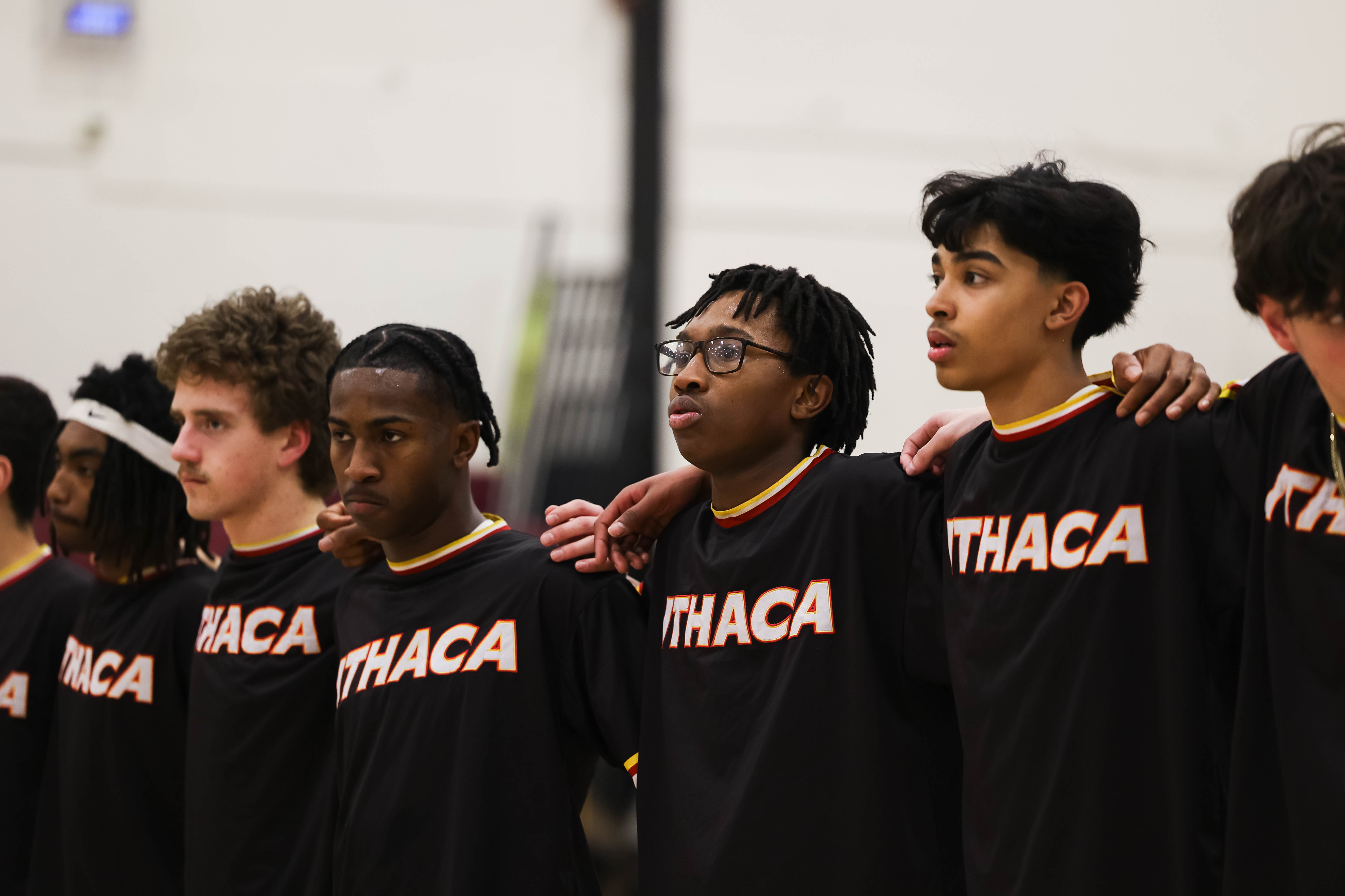 A row of young men in black jerseys with the word "THACA" on them. They are standing in a line.