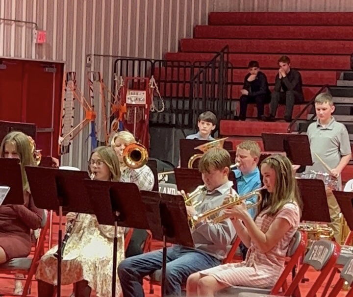 A photo of beginner band players practicing and learning their instruments