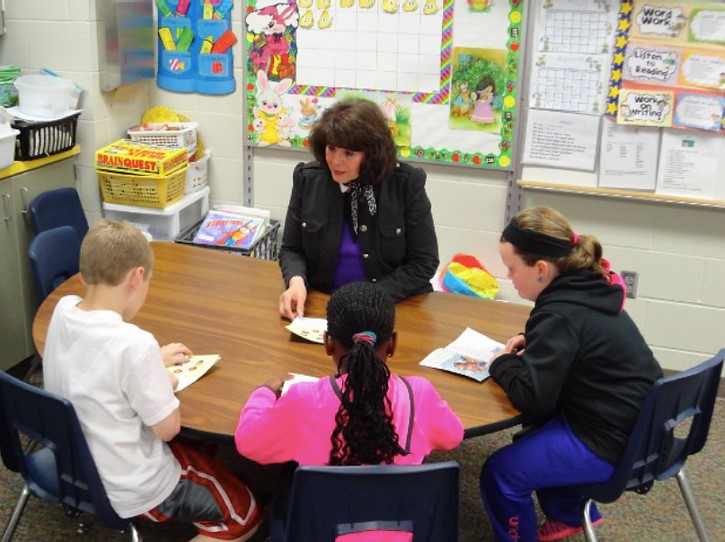 Teacher with her students while they are reading a story