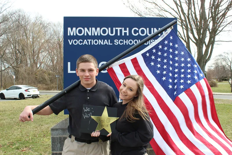 Students holding a flag and posing with a star