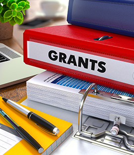 Stack of binders with the word Grants