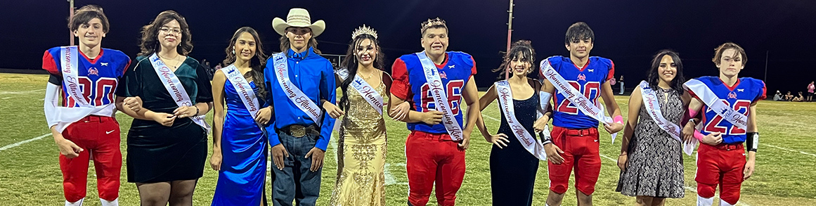 a photo of the homecoming court in their crowns on the football field