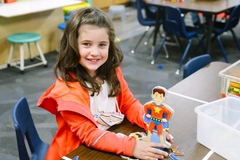 young female student with a cardboard superman cartoon