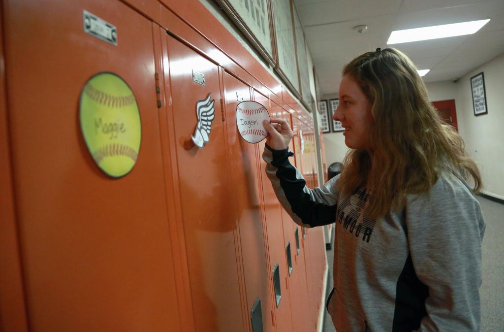 student hanging decoration on lockers