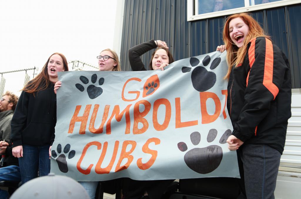 student holding a sign to support their home team