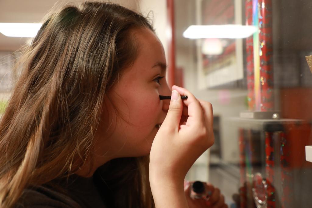 student applying face paint on her