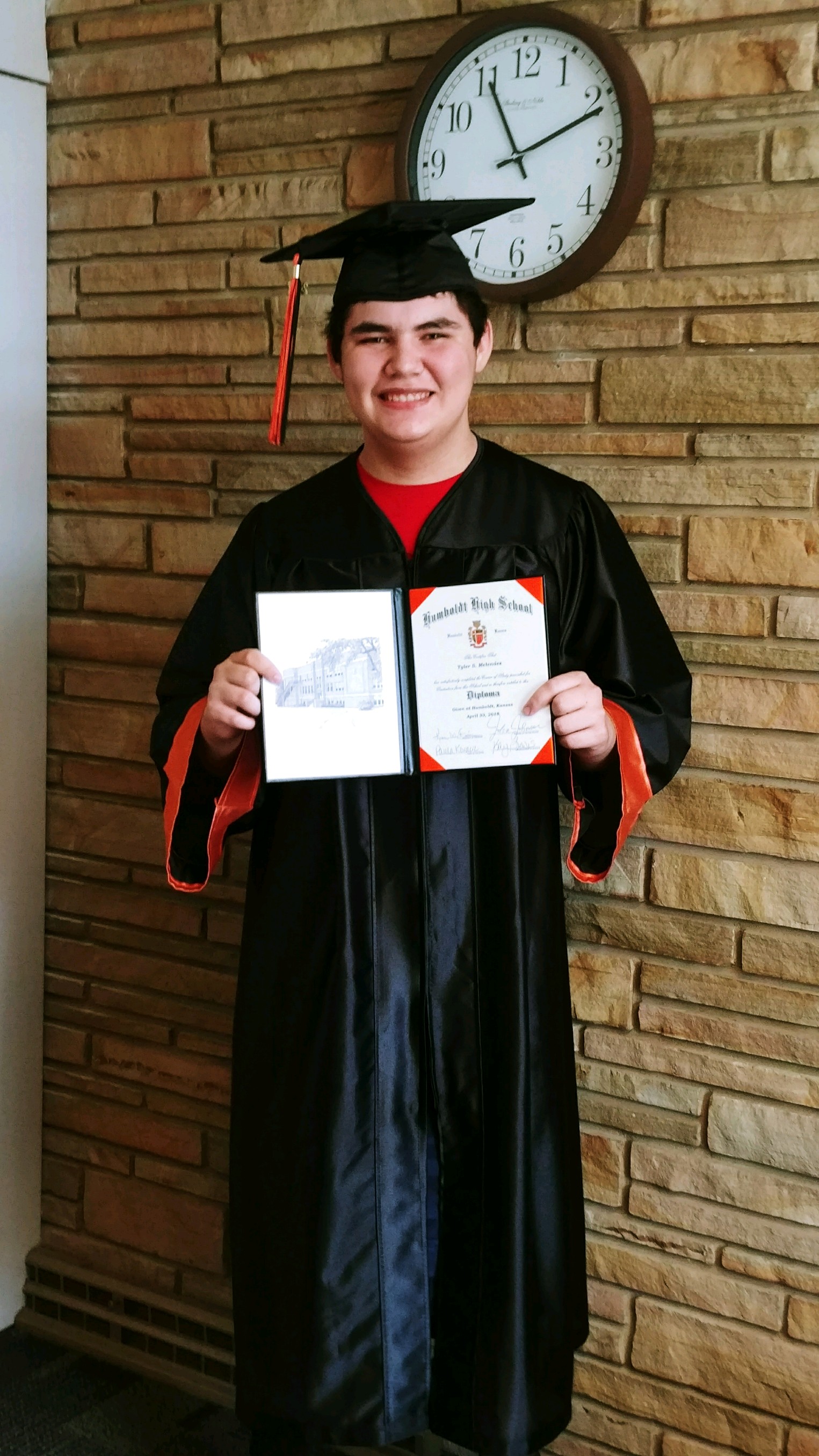 student holding his graduation diploma