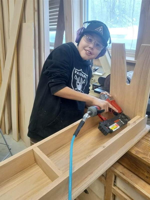 Student using powertool to screw together wood